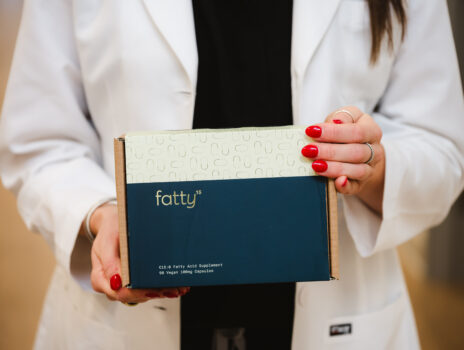 Our Nurse Practitioner, Taylor Hall, holding our Fatty 15 supplement that helps with cardiovascular health.